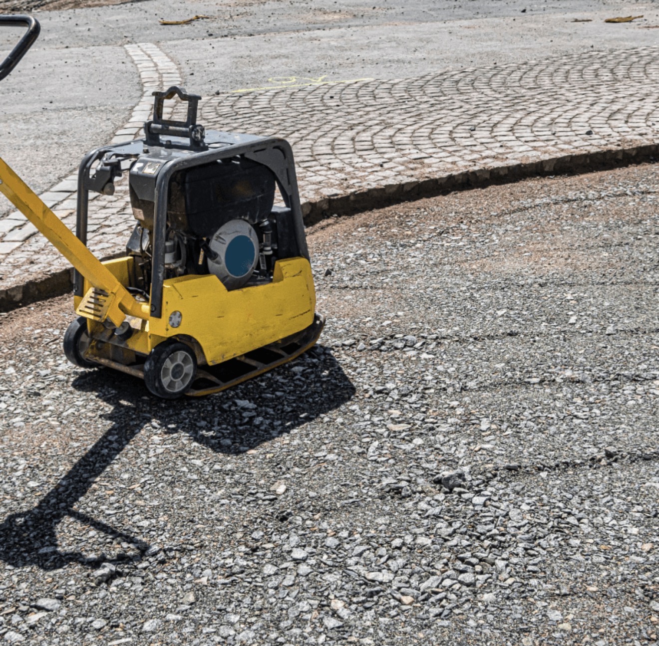 Hinchliffe groundworks — plate compactor consolidating tarmac binder course alongside a fan-pattern block paving driveway in Crewe, Cheshire